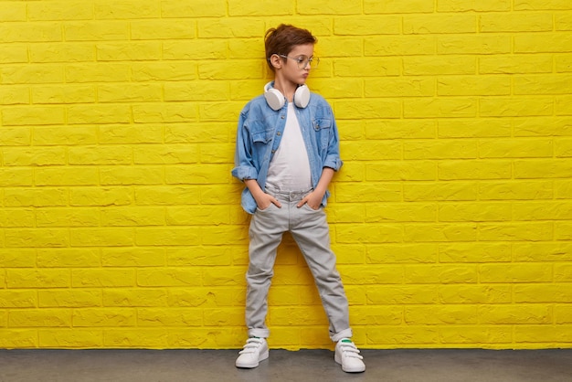 Confident trendy boy near wall