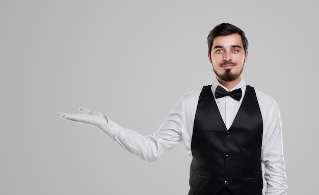 Confident waiter showing blank space