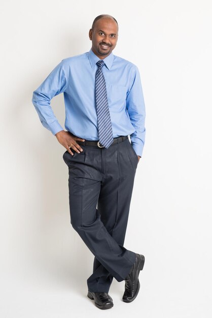 Photo confident well-dressed businessman standing against white background