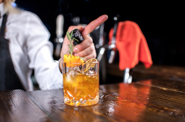 Confident woman barman makes a show creating a cocktail in cocktail bars