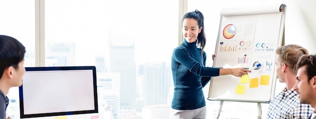 Confident woman pressenting financial chart in office meeting