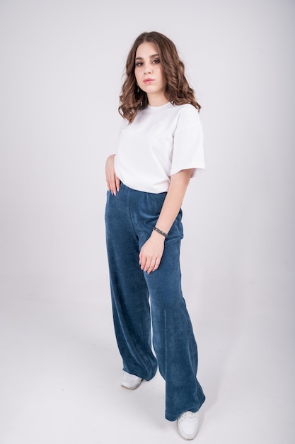 Confident woman in white T-shirt and jersey palazzo pants  . Casual stylish clothing for young girl.