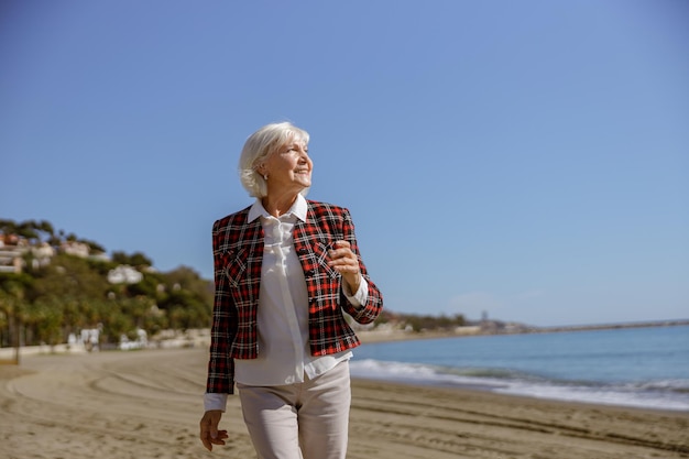 Donna sicura con la faccia felice in posa via mare