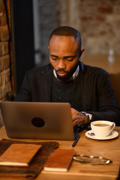 Confident young african man look at webcam conference video\
calling in office happy mixed race entre...