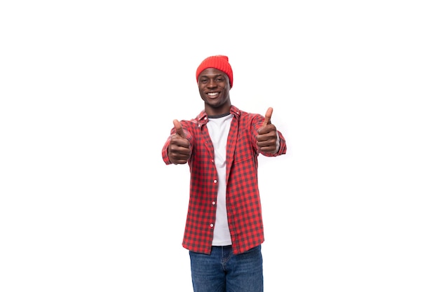 Confident young american man in red headdress and shirt pointing with hand at promotional offer on