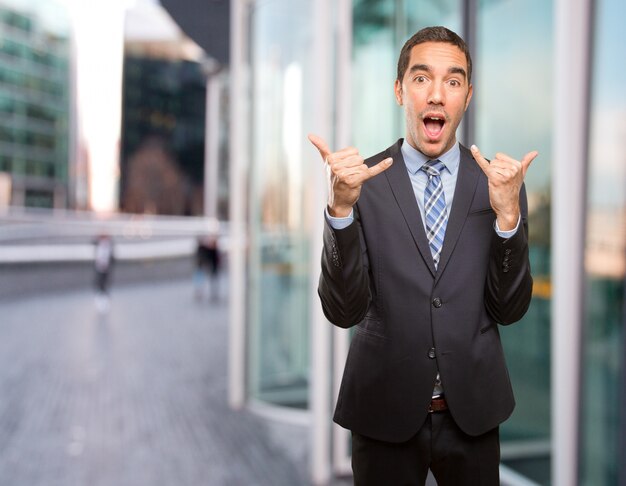 Confident young businessman doing a call gesture