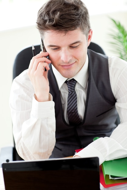 Confident young businessman talking on phone 