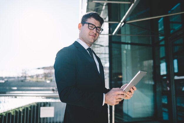 Confident young businessman with gadget