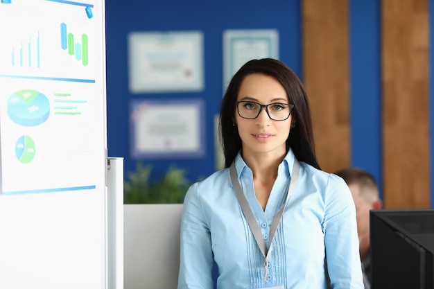 Confident young businesswoman in corporation office wearing glasses