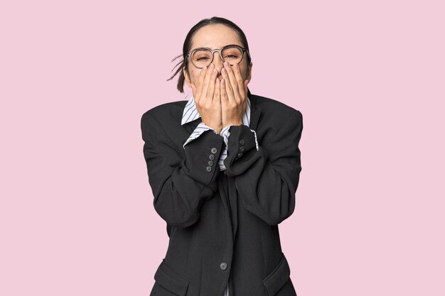 Photo confident young caucasian businesswoman on studio background laughing about something covering mouth