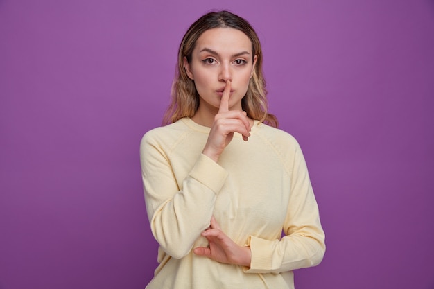 Confident young girl doing silence gesture 