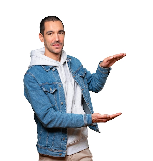 Confident young man doing a gesture of holding something with his hands