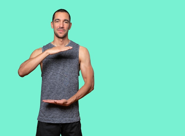 Photo confident young man doing a gesture of holding something with his hands