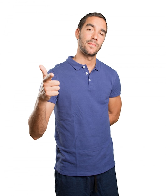 Confident young man pointing you on white background