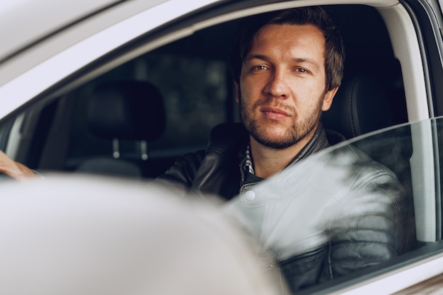 Confident young man sitting in a car