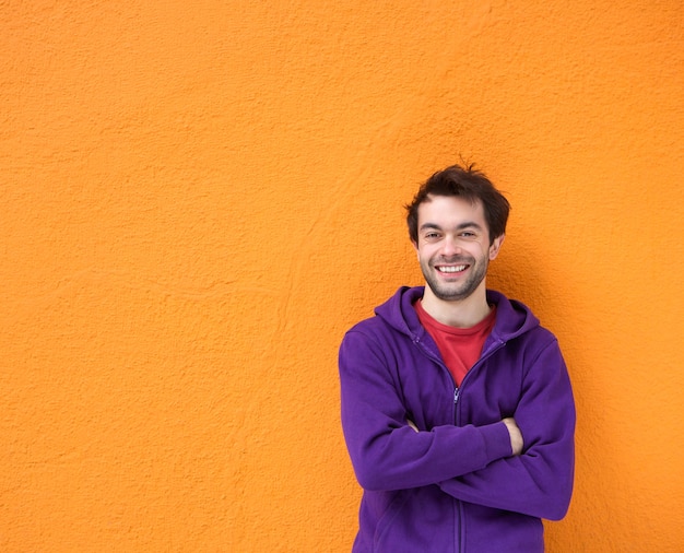 Confident young man smiling with arms crossed