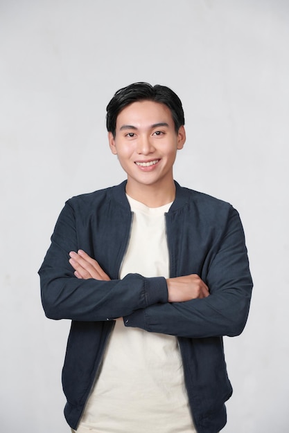 confident young man standing with crossed arms isolated on white