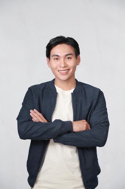 Confident young man standing with crossed arms isolated on white