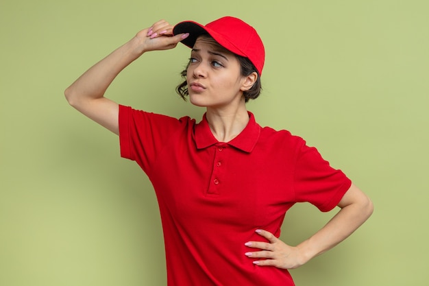 Photo confident young pretty delivery woman looking at side