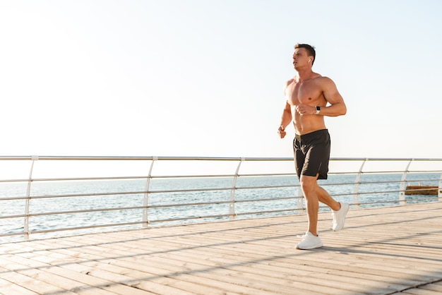 Confident young shirtless sportsman