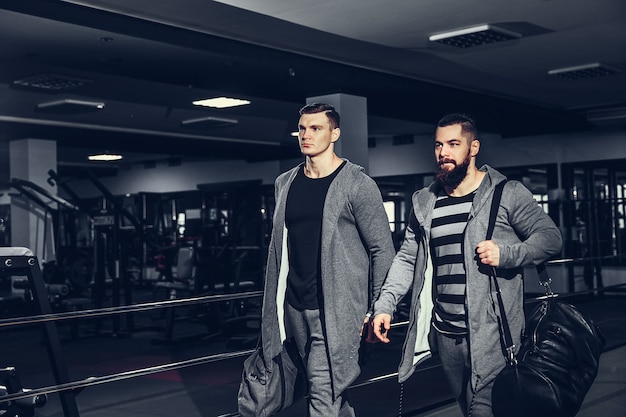 Confident young sportsmen leaving gym