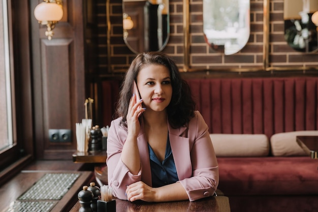 Confident young woman holding a smartphone talking calling on the phone business woman consulting a client