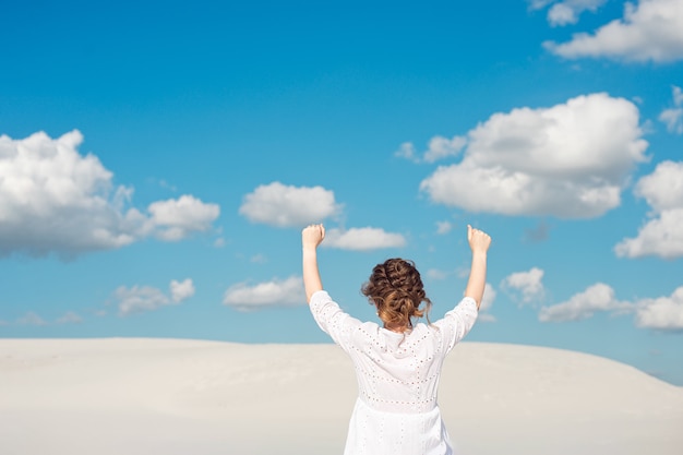 Photo confident young woman raising her fist up in the sky. feeling motivated