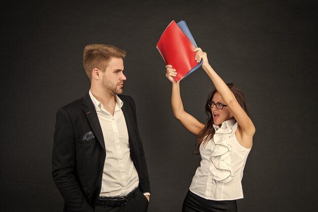 Conflict in the professional workplace Aggressive woman hit man with books Conflict management