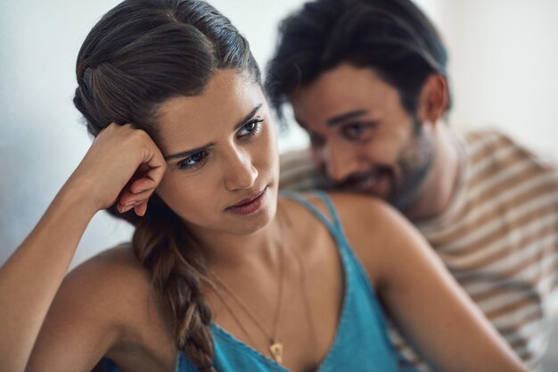 Foto conflict van streek of verdrietig met een stel dat ruzie maakt op een bank in hun huiskamer over een affaire of uiteenvallen depressie ongelukkig of huiselijk geweld met een vrouw die na een ruzie nadenkt over scheiden