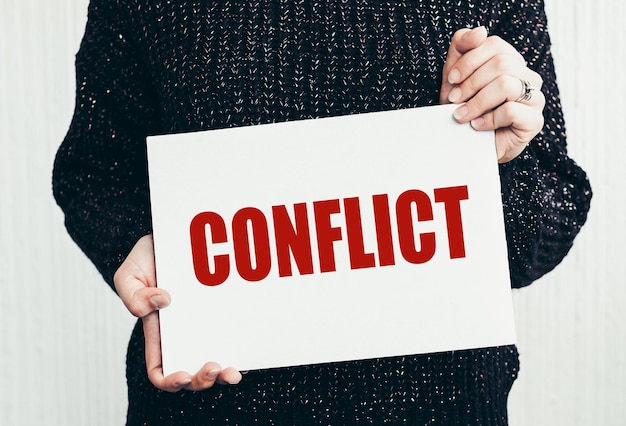 CONFLICT word on a paper in woman hands