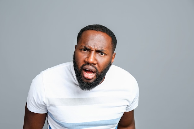 Confused African-American man on grey background