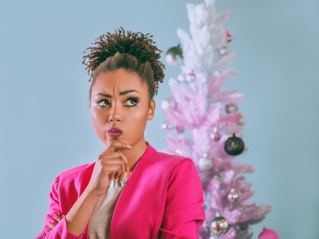 크리스마스 트리 배경에 혼란된 아프리카계 미국인 여자