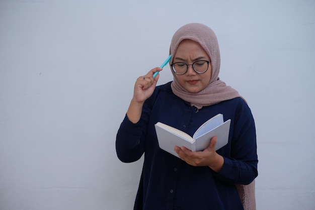 Confused asian woman holding book