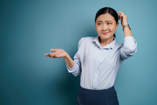 Confused Asian woman with copy space. Isolated on.