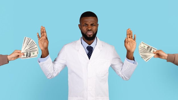 Confused black male doctor refusing to take bribe from female
patient