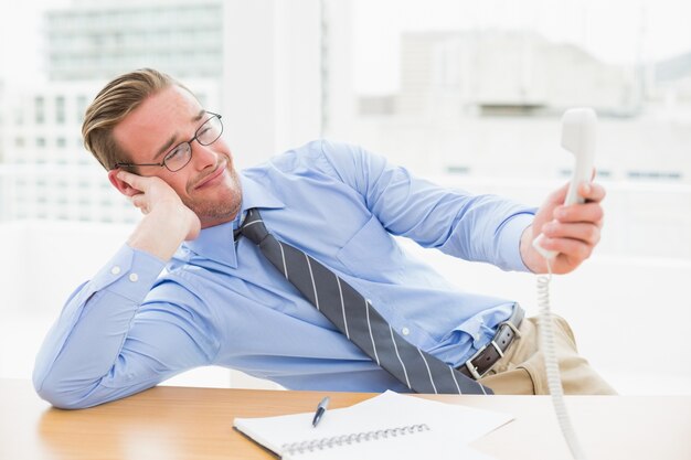 Confused businessman holding the phone