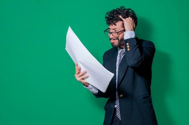 Confused businessman with documents in hand businessman puzzled\
with documents in hand isolated concept of man in formal suit\
frustrated with documents in hand