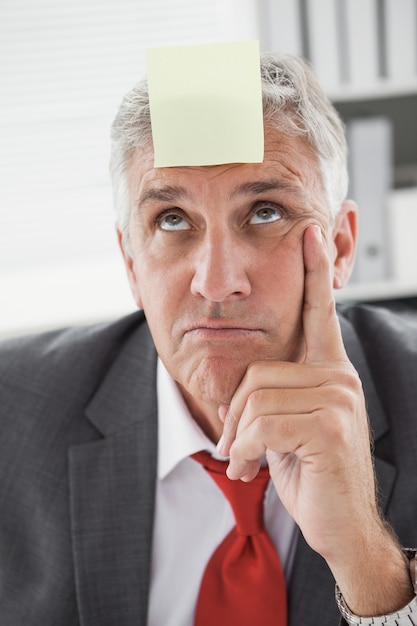 Photo confused businessman with sticky note on head