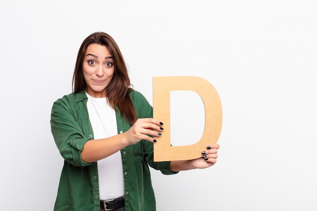 confused, doubtful, thinking, holding the letter D of the alphabet to form a word or a sentence.