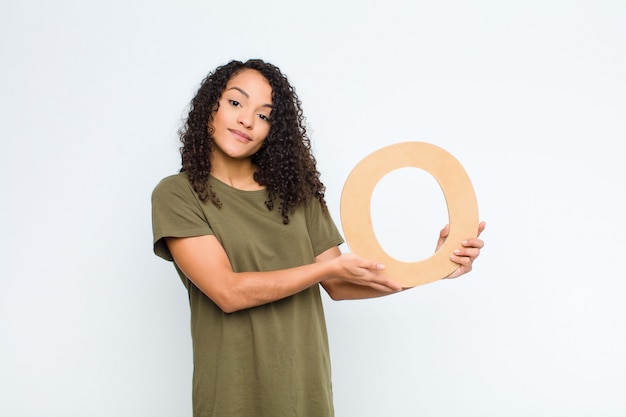 confused, doubtful, thinking, holding the letter O of the alphabet to form a word or a sentence.