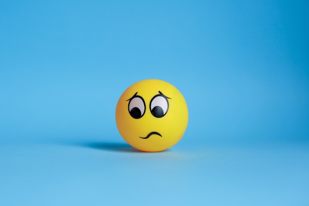Confused emoticon isolated on blue background