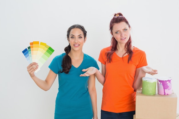 Confused friends choosing color for painting a room