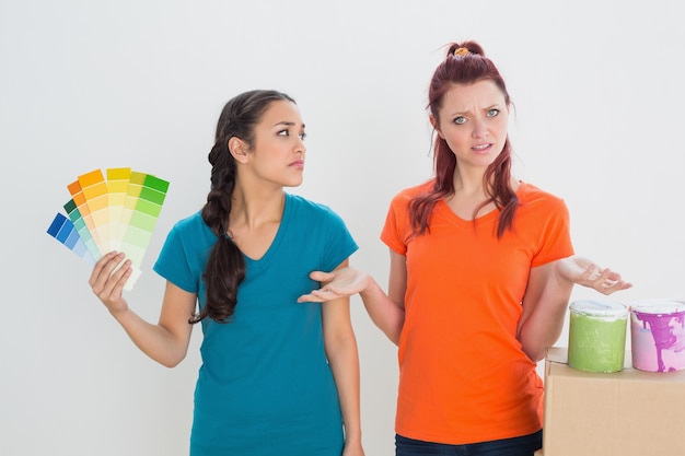 Confused friends choosing color for painting a room