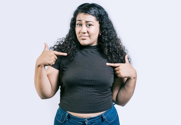 Photo confused girl pointing at herself isolated embarrassed young woman pointing at herself isolated