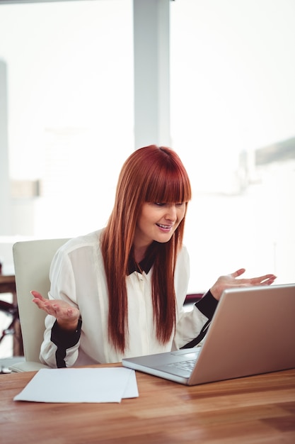 Confused hipster businesswoman using her laptop