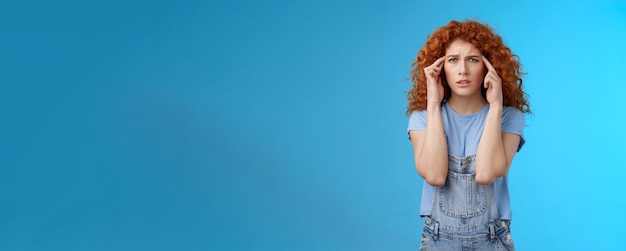 Photo confused panicking young distressed redhead curly girlfriend frowning touch temples cannot focus loo