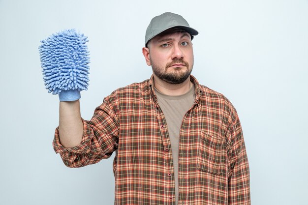 Confused slavic cleaner man holding microfiber cleaning glove