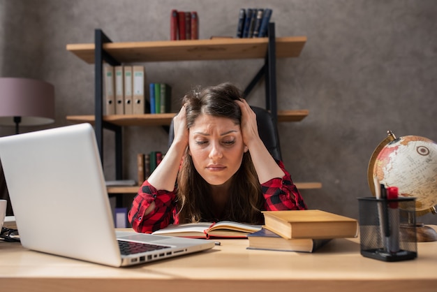 Confused woman teleworker works at home