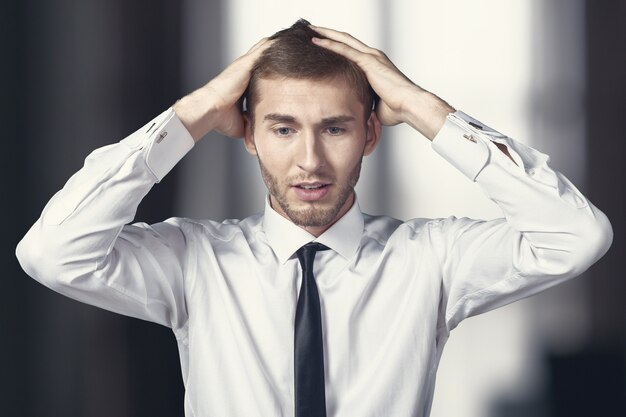 Confused young businessman thinking