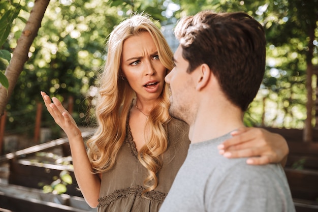 Confused young couple sitting together and arguing